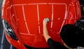 Car service worker applying nano coating on a car detail