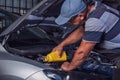 Car service worker diagnoses car breakdown Royalty Free Stock Photo