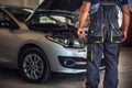 Car service worker diagnoses car breakdown Royalty Free Stock Photo