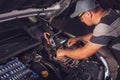 Car service worker diagnoses car breakdown Royalty Free Stock Photo