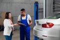 Car service worker talking to a client about a car