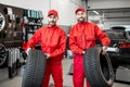 Car service workers with new tires at the shop Royalty Free Stock Photo