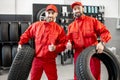 Car service workers with new tires at the shop Royalty Free Stock Photo