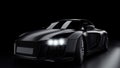 The car in the shadows with glowing lights in low light, or silhouette of sport car dark background. Selective focus