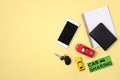 Car sharing concept. Toy cars, automobile key, driver license, blank notepad and smart phone on yellow background. Car sharing Royalty Free Stock Photo