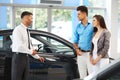 Car Showroom. Vehicle Dealer Showing Young Man New Car Royalty Free Stock Photo