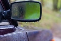 Car side mirror in the rain in water drops Royalty Free Stock Photo