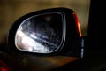 Car side-mirror with raindrops and reflection at night while driving Royalty Free Stock Photo