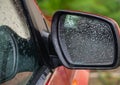 Car side rear view mirror with rain drops Royalty Free Stock Photo