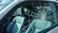 Car side window shattered from impact. Cracked glass forms starburst pattern. Interior leather seats visible through broken pane. Royalty Free Stock Photo