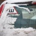 Car sign with the Russian letter meaning studded tires on the rear window of the car. The first snow. Safe movement