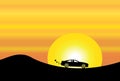 Car silhouette in orange evening sky & yellow sun