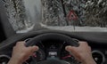 Car slipping on a road in the snow ice. Alongside the road is a sign for slippery road