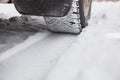 Car is on a snow-covered winter road. The wheel is close-up. Royalty Free Stock Photo