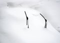 The car in snowdrift with sticking out from under the snow wiper blades