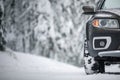 Car on a snowy winter road amid forests Royalty Free Stock Photo