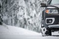 Car on a snowy winter road amid forests