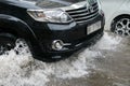 Car splashes through a large puddle on a flooded street