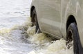 Car splashes through a large puddle on a flooded street