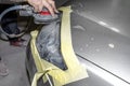 A car sprayer polishes the headlamp with a pneumatic sponge grinder.