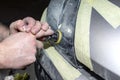 A car sprayer polishes the headlamp with a small pneumatic sponge grinder.