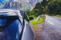 Car standing on the roadside on small country road on rainy day. Automobile travelling, road trip Royalty Free Stock Photo