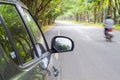 Car standing on wayside of the road with green tunel forest road