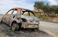 Burnt out car on the side of a road