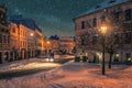 A car within strong snowfall in fairytale street with lanterns