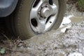 Car stuck, car wheel in a dirty puddle, rough terrain