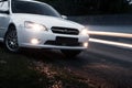 Car Subaru Legacy stay on asphalt road near passing cars at dusk Royalty Free Stock Photo