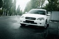 Car Subaru Legacy stay on asphalt road and reflected in puddle in the city at daytime Royalty Free Stock Photo