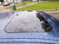 Car sunroof covered with thick rain drops