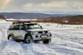 Car SUV drives through a snow-covered mountain valley with deep snow after a snowstorm. Jeep got stuck in a snowdrift in