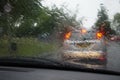 Car tail lights through a rain covered windshield, focus on rain drops Royalty Free Stock Photo