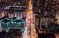 Car, taxi, and bus traffic on road intersection at night in Hong Kong downtown district, drone aerial top view. Asia city life