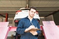 Car Technician Preparing Checklist In Workshop