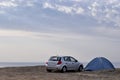 Car and a tent against the background of the sea.