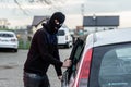 Car thief entering the vehicle and stealing a car. Royalty Free Stock Photo