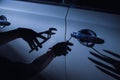 Car thief using a tool to break into a car Royalty Free Stock Photo