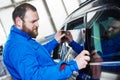 Car tinting. Automobile mechanic technician applying foil Royalty Free Stock Photo