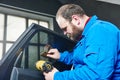 Car tinting. Automobile mechanic technician applying foil Royalty Free Stock Photo