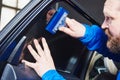 Car tinting. Automobile mechanic technician applying foil Royalty Free Stock Photo