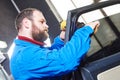 Car tinting. Automobile mechanic technician applying foil Royalty Free Stock Photo