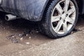 Car tire in big pothole on the road