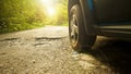 Car tire and cracked damaged road