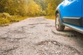 Car tire and cracked damaged road