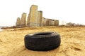 The car tire lies against the backdrop of city houses. Environmental pollution by law and order violators