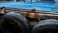 Car tire with metal chain on a old concrete sea pier,old truck tires at the pier.tire bumpers