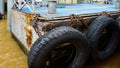 Car tire with a metal chain on old concrete sea pier,old truck tires at the pier.tire bumpers